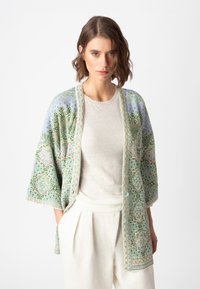 Giacca leggera in stile kimono con intricati motivi verdi e blu, dalla consistenza morbida e con bordi beige a contrasto.