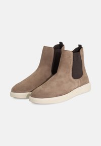 Hnedé semišové členkové topánky s elastickými bočnými panelmi, zaoblenou špičkou a krémovou gumovou podrážkou. Hladký povrch s minimalistickým dizajnom.