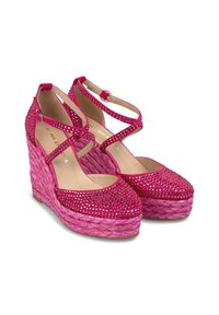 Sandales compensées roses avec des embellissements en rhinestones, bout fermé, et brides de cheville, présentant une plateforme tissée texturée.