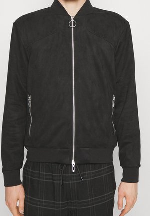 Black zip-up bomber jacket with ribbed cuffs and hem, featuring two zippered side pockets and a circular zipper pull at the collar.
