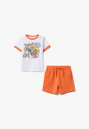 Maglietta bianca in cotone con bordi arancioni e grafica a cartone animato, abbinata a pantaloncini arancioni in cotone con vita elasticizzata.