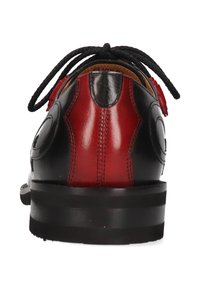 Scarpa in pelle nera e rossa con forma arrotondata, chiusura con lacci e texture liscia. Presenta accenti di design circolare sui lati.