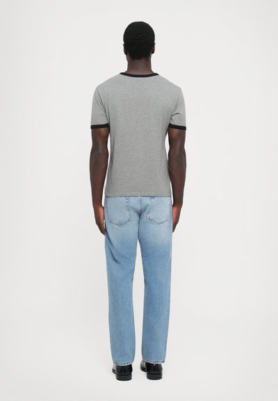 Gray short-sleeve t-shirt with black trim, paired with light blue straight-leg jeans and black shoes. Plain design, cotton material.