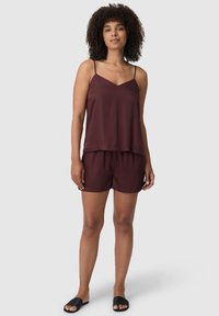 Bordeaux tweed tweed-set met een mouwloze top met V-hals en bijpassende shorts. De stof lijkt zacht met een gladde textuur.