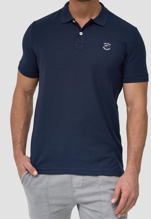 Navyblaue Polohemden aus Baumwolle, mit Kragen, kurzen Ärmeln und einem kleinen Logo auf der Brust. Glatte Textur, taillierte Passform.