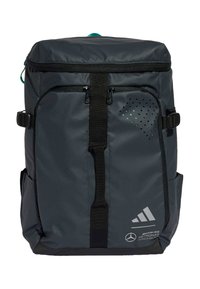 Tamno sivi ruksak s gornjim zatvaračem, podesivim trakama, prednjim džepovima, perforiranim detaljima i logotipima Mercedesa i Adidasa.