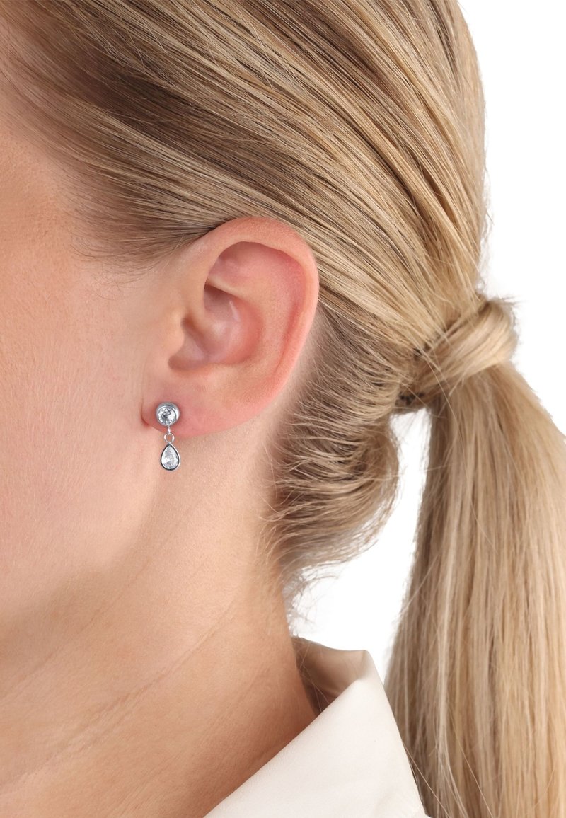 Ohrringe aus Sterlingsilber mit runder Oberseite und einem tropfenförmigen Anhänger, der klare Edelsteine, ein schlankes Design und eine polierte Oberfläche aufweist.
