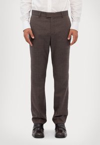 Pruunide triibuliste pükstega, millel on sile tekstuur, sirge lõige ja tavapärane vöökoht, koos mustade elegantside kingadega.