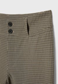 Hoge taillebroek met een klein zwart-beige geruit patroon, voorzien van twee zwarte knopen en een zijzak op de rechterheup.