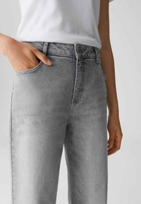Jeans in denim grigio con taglio dritto, vita media, tasche anteriori e chiusura con bottone. Sbiadimento sottile e texture liscia con dettagli minimi.