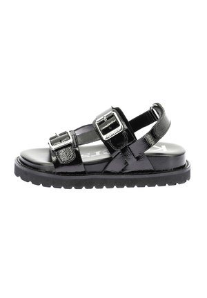 Sandalias negras con un acabado de charol brillante, que presentan hebillas plateadas, un diseño de tira texturizada y una suela de goma gruesa y estriada.