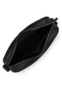 Zwarte leren tas met een ritssluiting. Interieur is niet gevoerd, ruim en heeft minimale accenten. Ronde hoeken en een strakke algehele uitstraling.