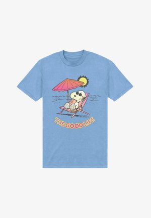 Snoopy draagt een zonnebril en ligt te ontspannen op een roze strandstoel onder een rode parasol met zon en oceaangolven, tekst "HET GOEDE LEVEN."