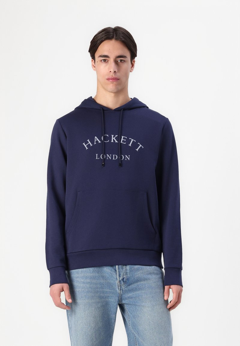 Námořnická modrá mikina s nastavitelnými šňůrkami, přední kapsou a šedým textem "HACKETT LONDON". Měkká tkanina s volným střihem.