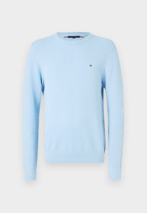 Svetlo modra teksturirana dolga majica s kratkimi rokavi, s krožnim izrezom in majhnim vezenim logotipom na levem prsnem delu ter rebrastimi zapestji in robom.