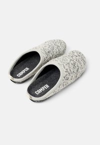 Harmaat tuntuva tossut, joissa on teksturoitu pinta, pyöristetty kärki ja musta pohja, jossa on "CAMPER"-brändäys. Pehmeä materiaali, joka on suunniteltu helposti liu'uttavaksi päälle.