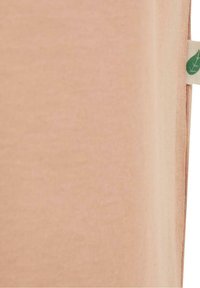 Gros plan d’un tissu couleur pêche avec une petite étiquette beige affichant une feuille verte sur le bord droit.