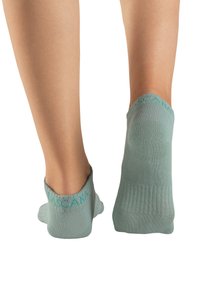 Mintgrüne Knöchelsocken mit geripptem Muster, die eine glatte Oberfläche aufweisen und am Bund ein Logo in Türkis haben.