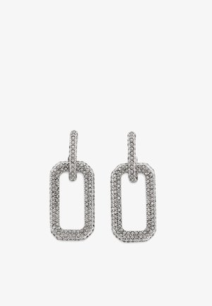 Boucles d'oreilles pendantes rectangulaires en argent avec bords arrondis, chacune ornée de petits cristaux clairs incrustés sur les sections suspendues et les parties de liaison.