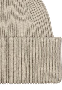 Gorro de punto en beige claro con una textura acanalada. Presenta un dobladillo en la parte inferior, mostrando un acabado liso y un patrón de puntada uniforme.