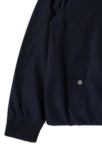 Manche de veste bleu marine foncé avec bord-côte et une poche latérale avec fermeture par bouton-pression argenté.