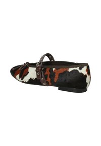 Ballerina in pelle di mucca con un motivo marrone e bianco, dotata di una sottile cinturino marrone e dettagli metallici, punta tonda e suola nera bassa.