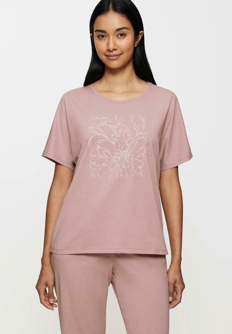 Różowa bawełniana koszulka z luźnym krojem, okrągłym dekoltem i krótkimi rękawami. Z przodu ozdobiona białym wzorem w kształcie kwiatów.