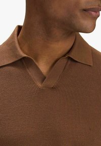 Brun stickad polo med V-ringning, texturerat mönster och strukturerad krage. Mjukt material med en kroppsnära design.