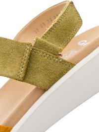 Pasek sandała zamszowy w oliwkowej zieleni z detalem przeszycia na beżowej, wyściełanej podeszwie i białej podeszwie na koturnie.