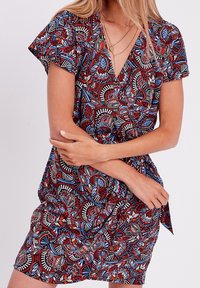Robe à manches courtes avec un motif floral vibrant aux teintes rouge, bleu et noir. Encolure en V et taille froncée pour une silhouette ajustée.