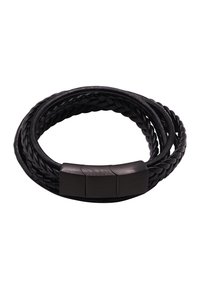 Braccialetto in pelle intrecciata nera con una chiusura metallica liscia, composto da tre sezioni. Il design è circolare e si avvolge attorno al polso.