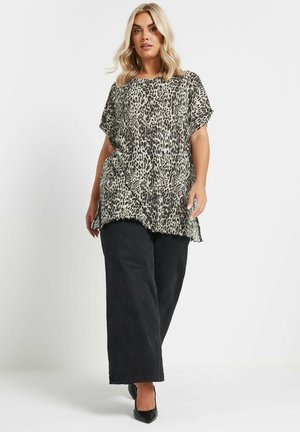 Leopardenmuster Top mit kurzen Ärmeln, leichtem Stoff, Rundhalsausschnitt, lockerer Passform, kombiniert mit weiten schwarzen Hosen und schwarzen spitzen Schuhen.