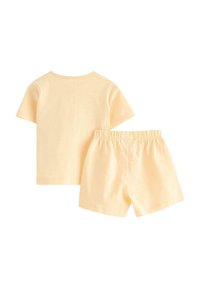 Helles gelbes Baumwoll-T-Shirt und passende Shorts. Das T-Shirt hat kurze Ärmel; die Shorts haben einen elastischen Bund und eine lockere Passform.