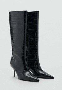 Botas negras hasta la rodilla con acabado brillante y patrón de cocodrilo. Punta estrecha y tacón de aguja delgado, textura suave y cierre de cremallera en el lateral.