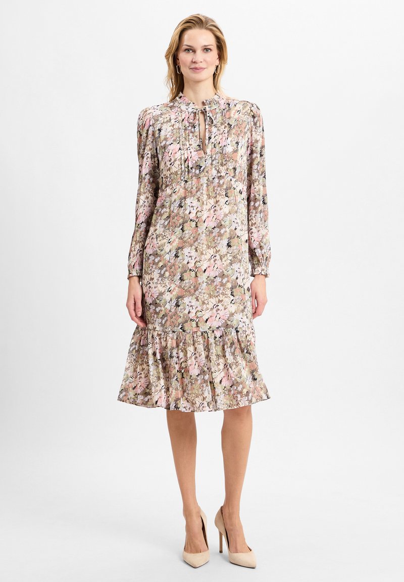 Blumenkleid mit langen Ärmeln, Ausschnitt mit Schlüssellochdetail, Rüschensaum und einer pastellfarbenen Palette mit rosa, grün und braunen Akzenten.