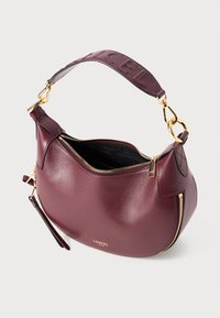 Sac à épaule en cuir bordeaux avec des zips dorés, intérieur noir, une bandoulière amovible et un logo en relief sur la poignée rembourrée.