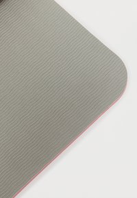 Γκρι καουτσούκ στρώμα με κυματιστή υφή και ροζ άκρη, με αντιολισθητική επιφάνεια και στρογγυλεμένες γωνίες, σχεδιασμένο για σταθερότητα.