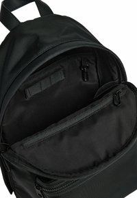 Zwarte rugzak met een gestructureerde buitenkant, een ruime binnenkant met een ritsvak en verstelbare schouderbanden. Bevat interne webbing voor organisatie.
