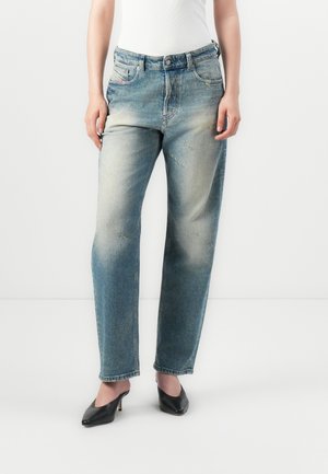 Jeans rectos de color azul claro con zonas desgastadas y ligero deterioro. Diseño clásico de cinco bolsillos, con cierre de botón y cremallera.
