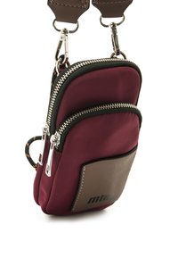 Borsa a tracolla in tessuto bordeaux con doppie tasche con zip, accenti neri e una patch in pelle marrone con il logo del marchio. Dettagli in hardware argentato.
