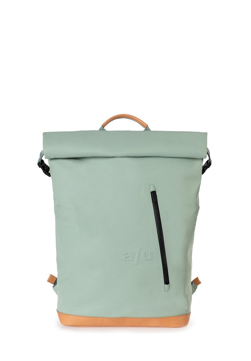 Zaino roll-top in morbido materiale verde con una base in pelle marrone chiaro. Presenta una tasca frontale con zip e dettagli in metallo nero.