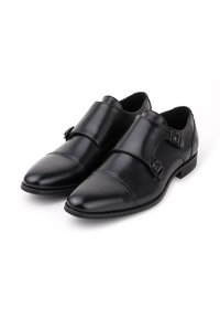 Czarne skórzane buty dressowe z gładkim wykończeniem, podwójnymi zapięciami, wyprofilowanym noskiem i minimalnymi detalami przeszycia.