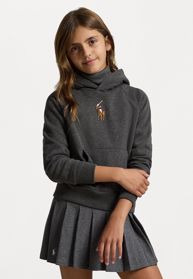 Sweatshirt cinza com capuz e bolso frontal, apresentando um logótipo bordado, combinado com uma saia cinza plissada com um pequeno acento de logótipo.