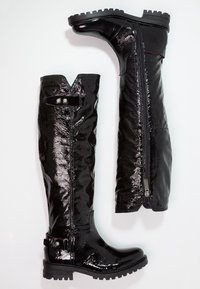 Czarne czółenka do kolan wykonane z błyszczącego materiału, z charakterystycznym zaostrzonym czubkiem, suwakiem bocznym, paskiem z zapinaną na guzik klamrą oraz teksturowaną podeszwą.