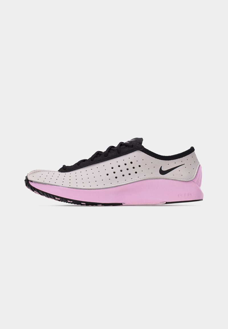 Lichtroze en zwarte Nike hardloopschoen met geperforeerde bovenkant, zwarte veters en roze zool op een effen witte achtergrond.
