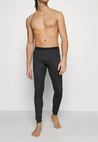 Schwarze warme Leggings mit einem elastischen Bund, die eng anliegen und eine glatte Textur haben. Keine sichtbaren Muster oder Logos.