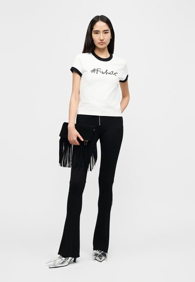 Λευκό κοντομάνικο μπλουζάκι με μαύρη περιμετρική ρίγα και λογότυπο "OFF-White", συνδυασμένο με μαύρο καμπάνα παντελόνι και μαύρη τσάντα με κρόσσια. Ασημένια μυτερά τακούνια.