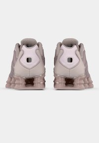 Αθλητικά παπούτσια σε ανοιχτό ροζ χρώμα με υφασμάτινο επάνω μέρος, επενδυμένο περιμετρικά στον αστράγαλο και χαρακτηριστική σόλα με διαφανούς λεπτομέρειες και θύλακες αέρα.