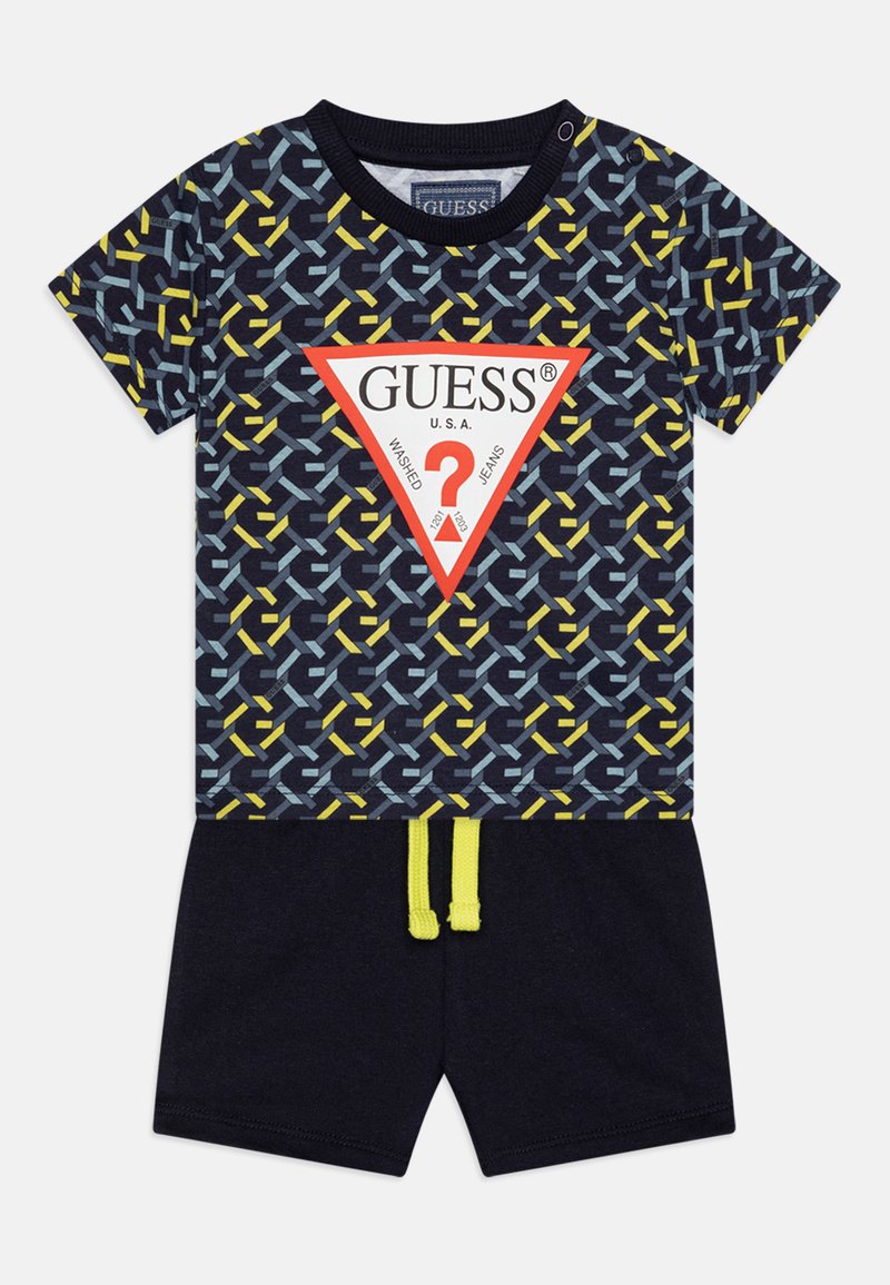 Mornarska odjeća kratkih rukava s geometrijskim uzorkom u plavoj, žutoj i bijeloj boji, s crvenim trokutastim logotipom i kratkim hlačama s žutom vezicom.