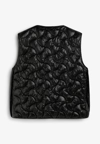 Chaleco acolchado negro con un patrón de ondas acolchadas y un acabado texturizado de alto brillo. Sin mangas; líneas limpias y diseño minimalista.